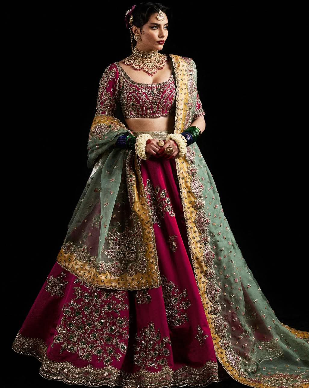 Deep pink lehenga paired with a contrasting teal-green dupatta