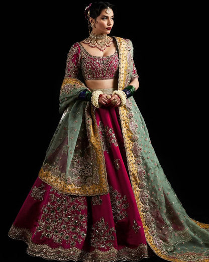 Deep pink lehenga paired with a contrasting teal-green dupatta