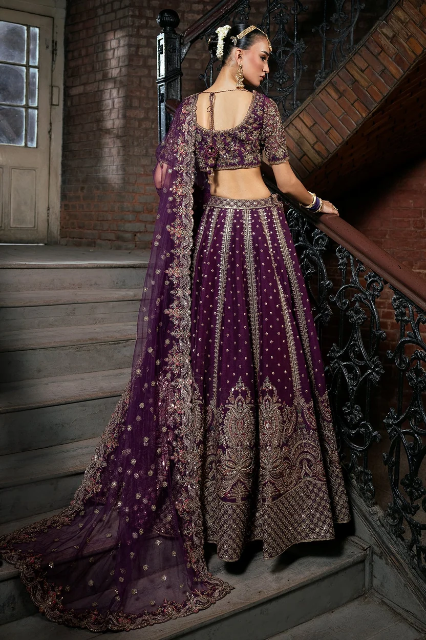 Dark purple bridal lehenga with an ornate gold embroidered hem